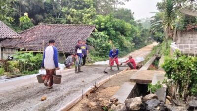 Ence Rohendi Kepala Desa Padabeunghar ikut turun tangan membantu warga yang sedang mengerjakan pembangunan jalan Desa, Sabtu (25/5/2024) (dok. Bharindo News)